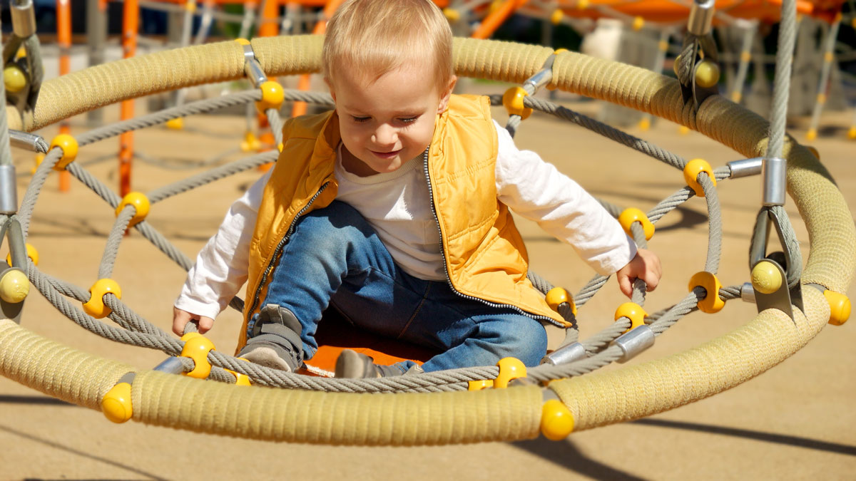 Young child seated in an outdoor swing