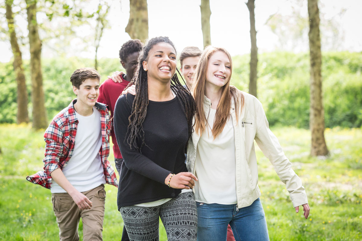 Group of teenagers walking in a park