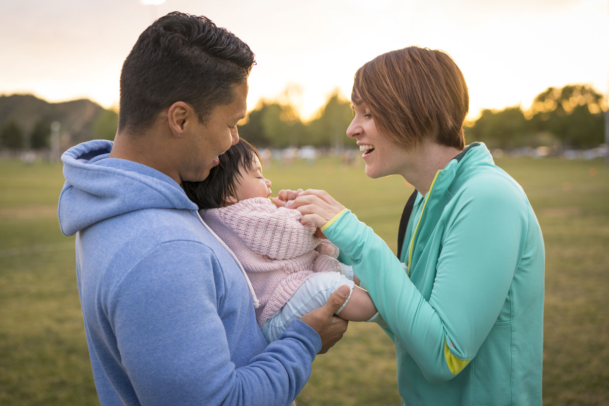 Adults playing with a baby in a park